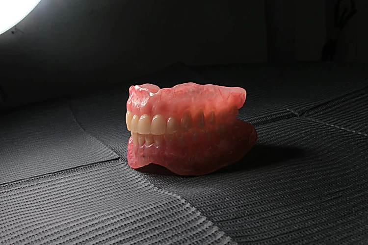 Prótesis dental total sobre una superficie oscura